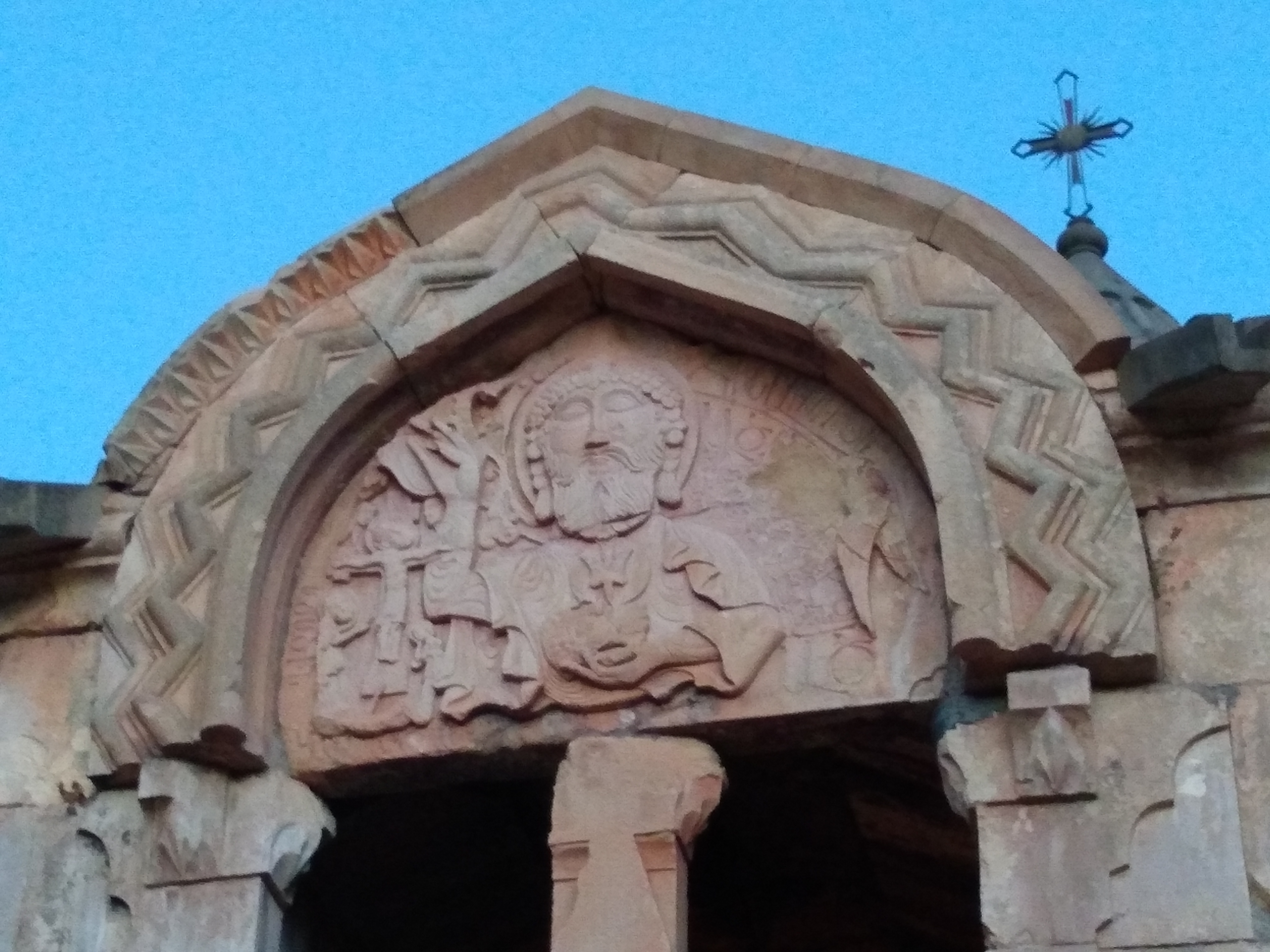 Photo of a carving of an image of the Christian god above a doorway