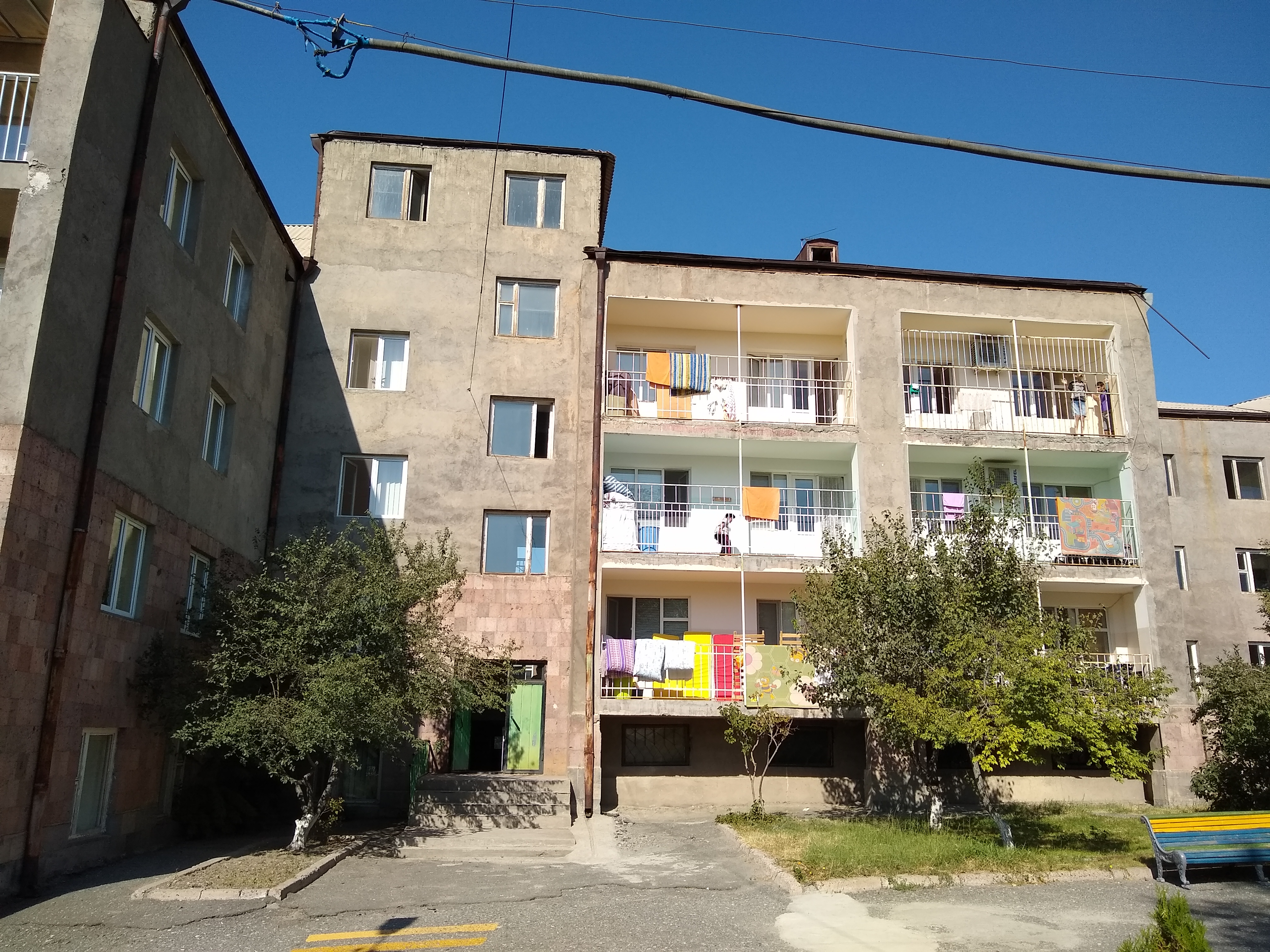 Photograph of a building with four floors and balconies