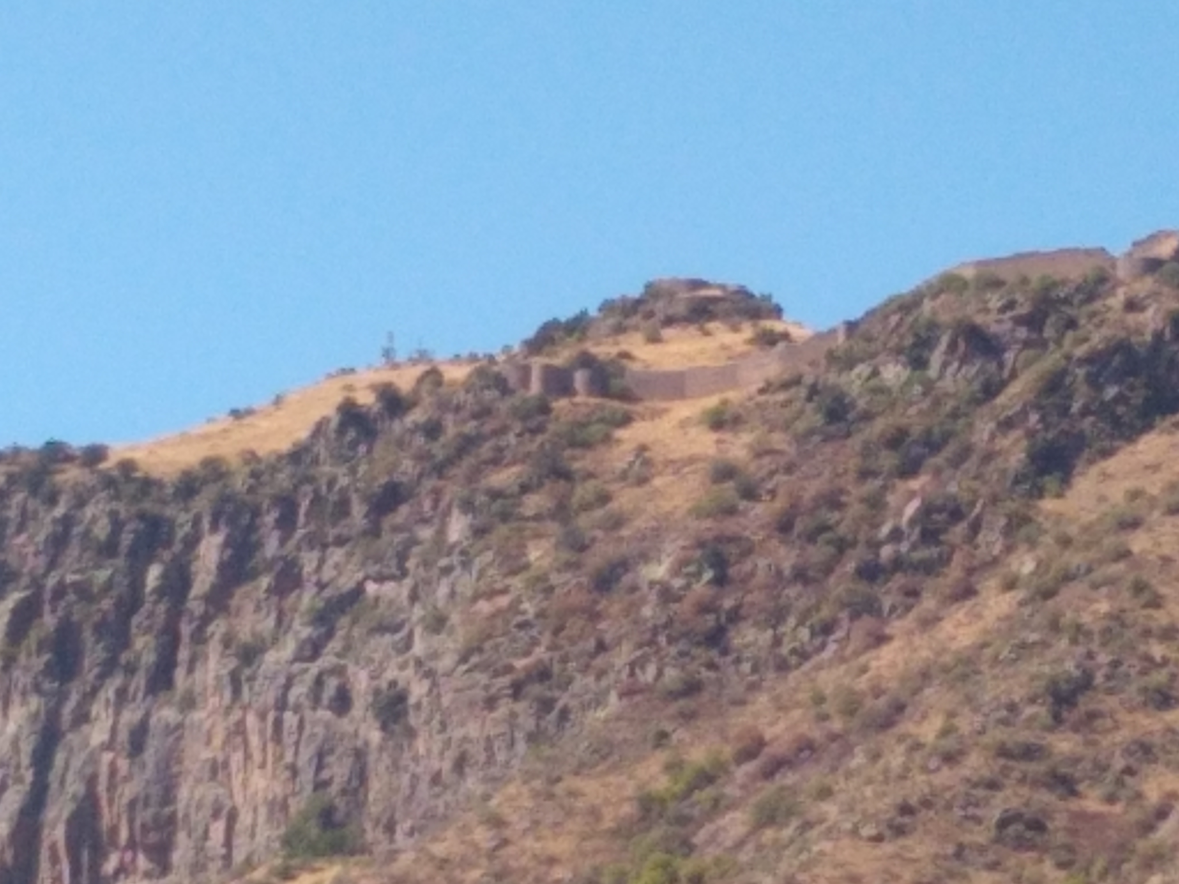 Photo of the view up a mountain to a fortress at its summit.